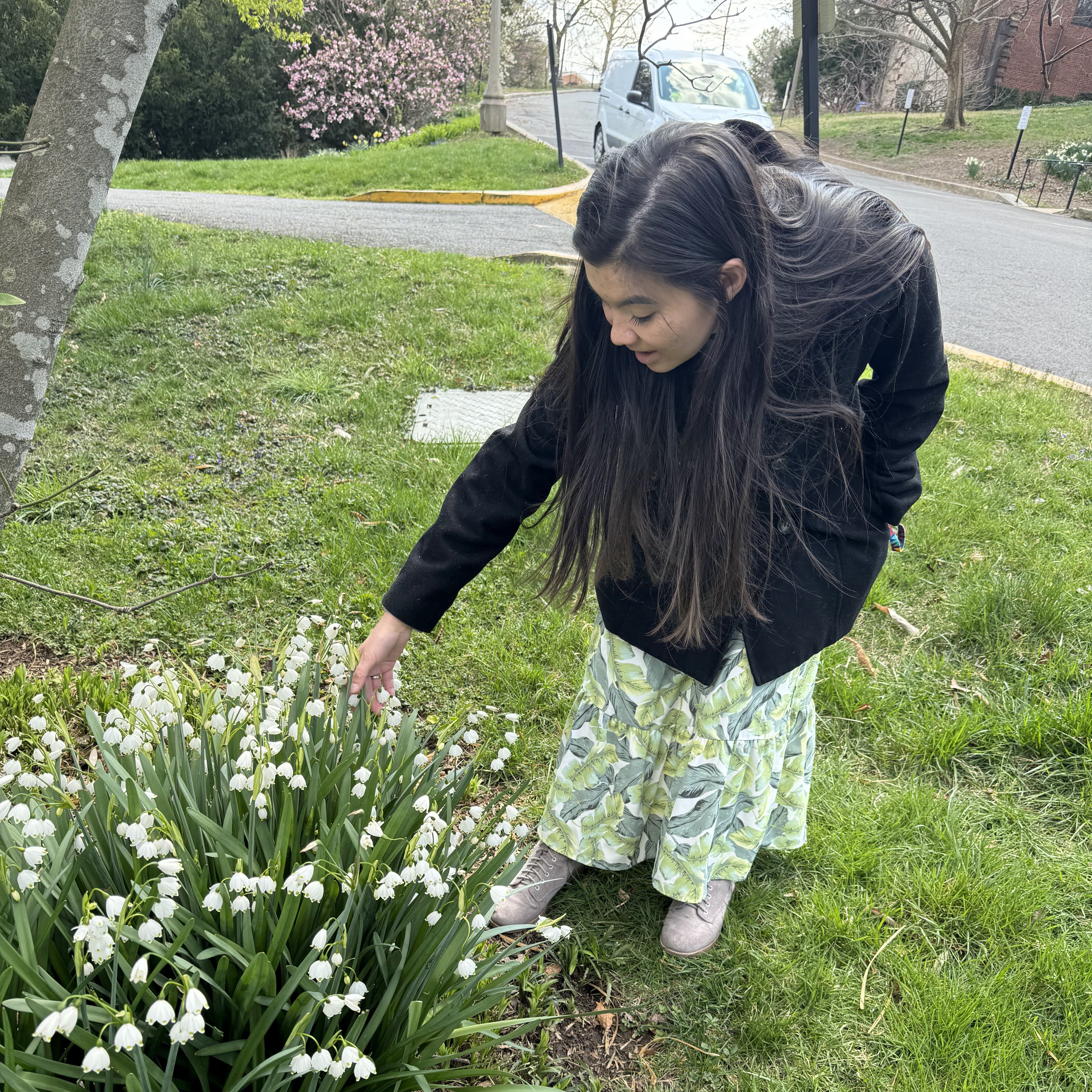 Emily talking about and touching spring snowflake flowers
